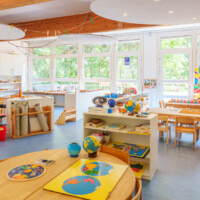 Gruppenraum der Montessori-Gruppe Rot mit kindgerechten Möbeln, Spielmaterialien und heller, freundlicher Raumgestaltung.